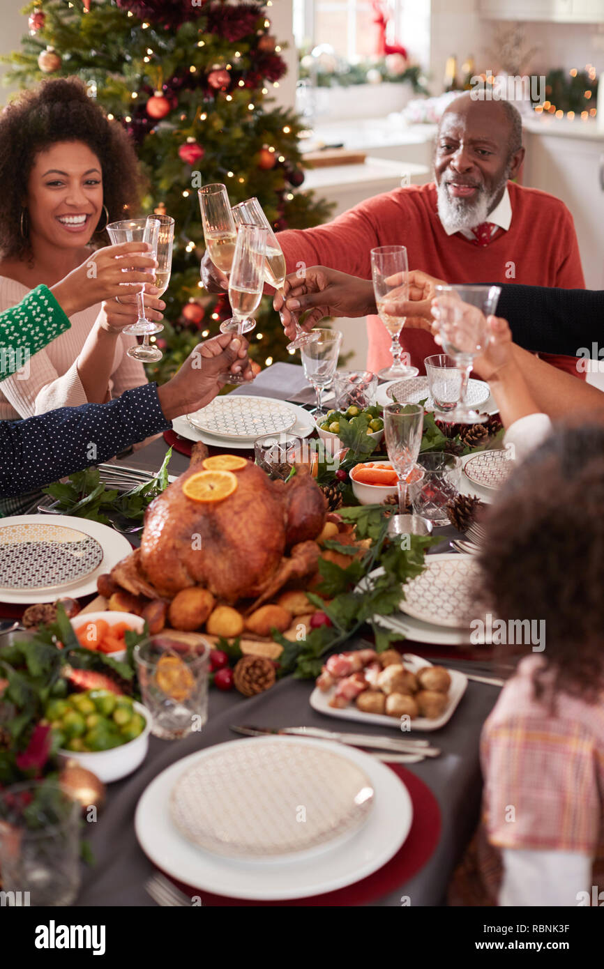Grand-père noir faire un toast avec sa famille à la table de dîner de Noël, elevated view Banque D'Images