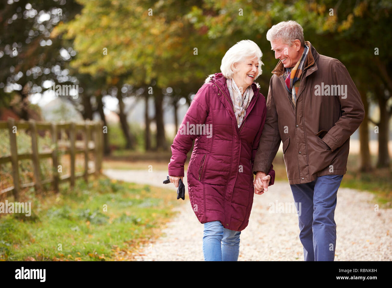 Couple actif sur l'automne à pied sur le chemin dans la campagne Banque D'Images