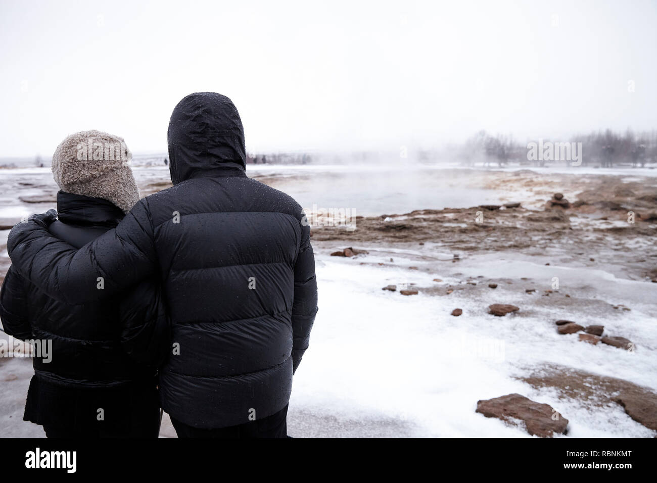Vue arrière de touristes visitant la vapeur Piscines géothermique en Islande Banque D'Images