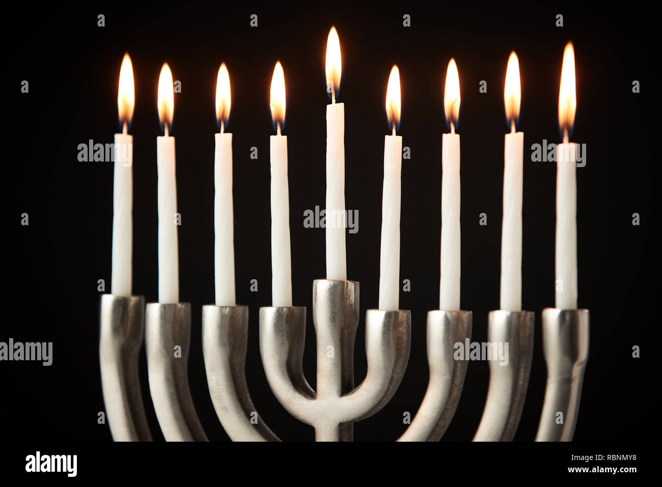 Les Chandelles sur Metal Hanukkah Menorah contre Black Background Banque D'Images