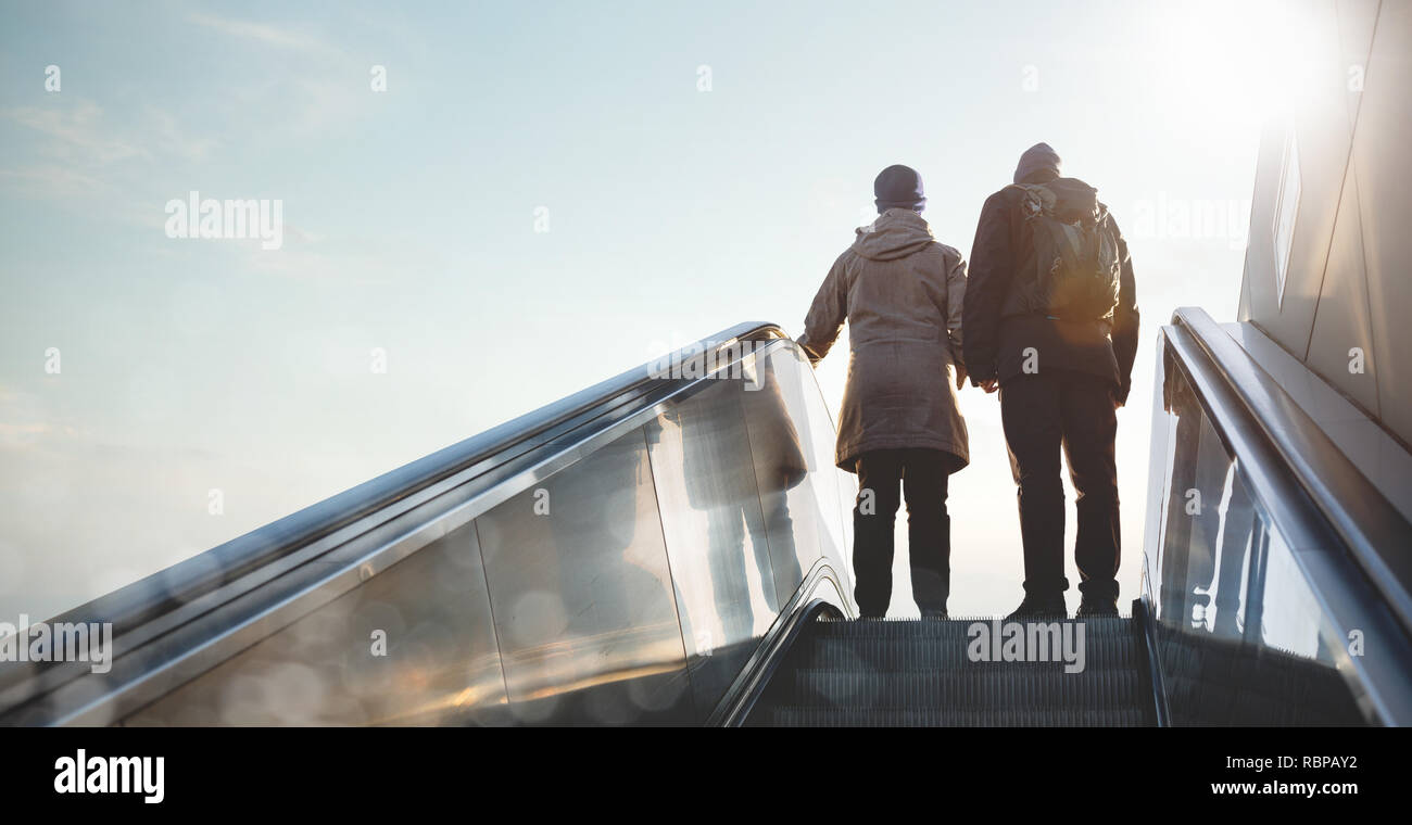 Silhouette d'un couple qui monte un escalator Banque D'Images