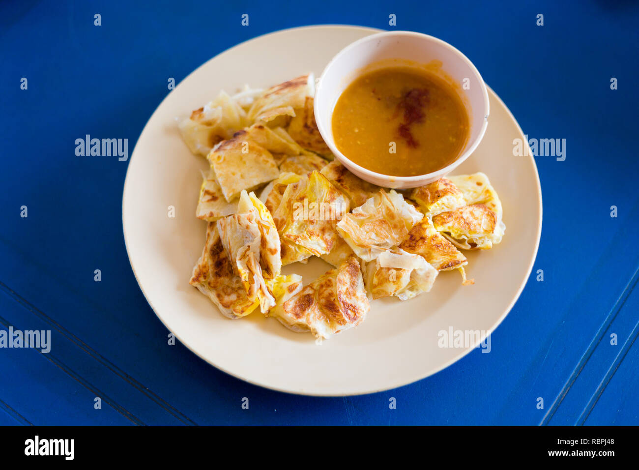 Préparés frais roti telur malaisien avec oeuf servi avec dahl de lentilles dans un restaurant local sur l'île de Langkawi. La cuisine asiatique traditionnelle à base de produits frais je Banque D'Images