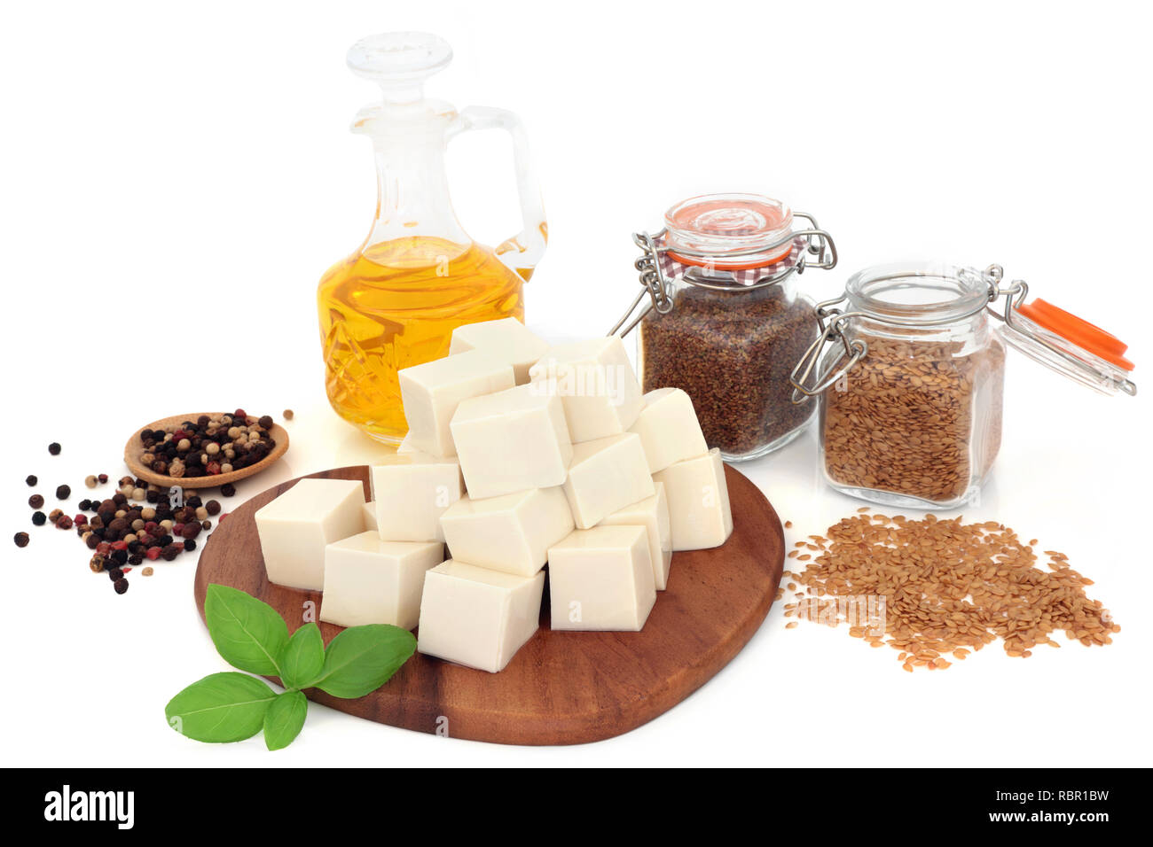 Vegan aliments de santé au tofu pâte de soja, graines de lin, huile d'olive, basilic poivre et d'herbes sur fond blanc. Riche en protéines et d'oméga 3. Banque D'Images