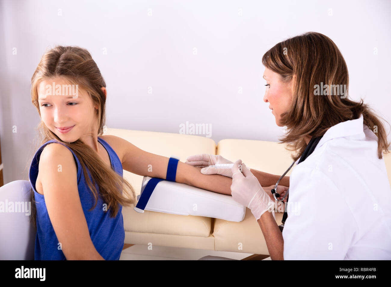 Vue latérale du médecin femme prendre échantillon de sang d'un patient dans un centre pour enfants peur Banque D'Images