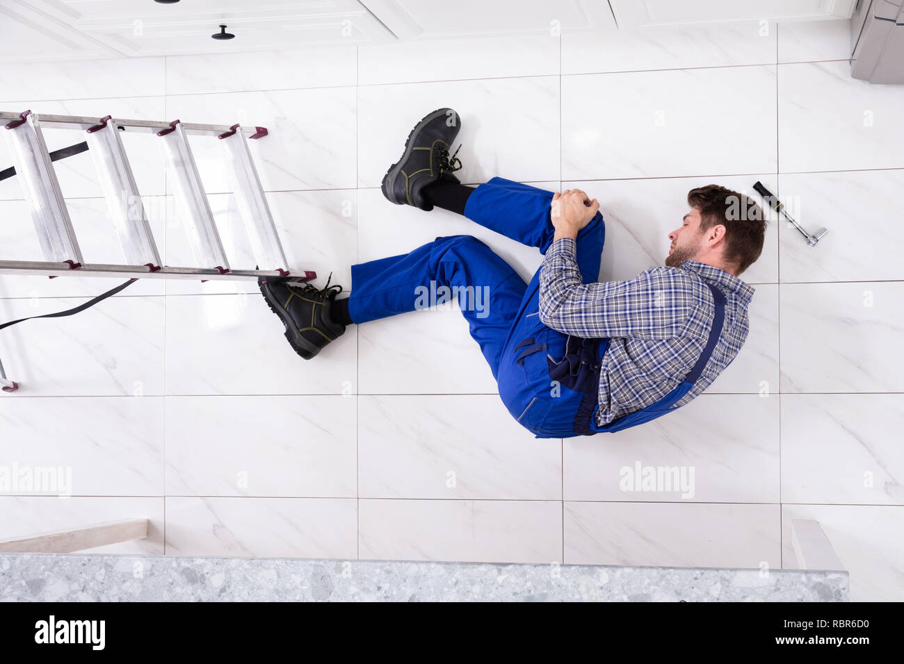 Portrait de travailleur blessé gisant sur sol à proximité de Bain Banque D'Images