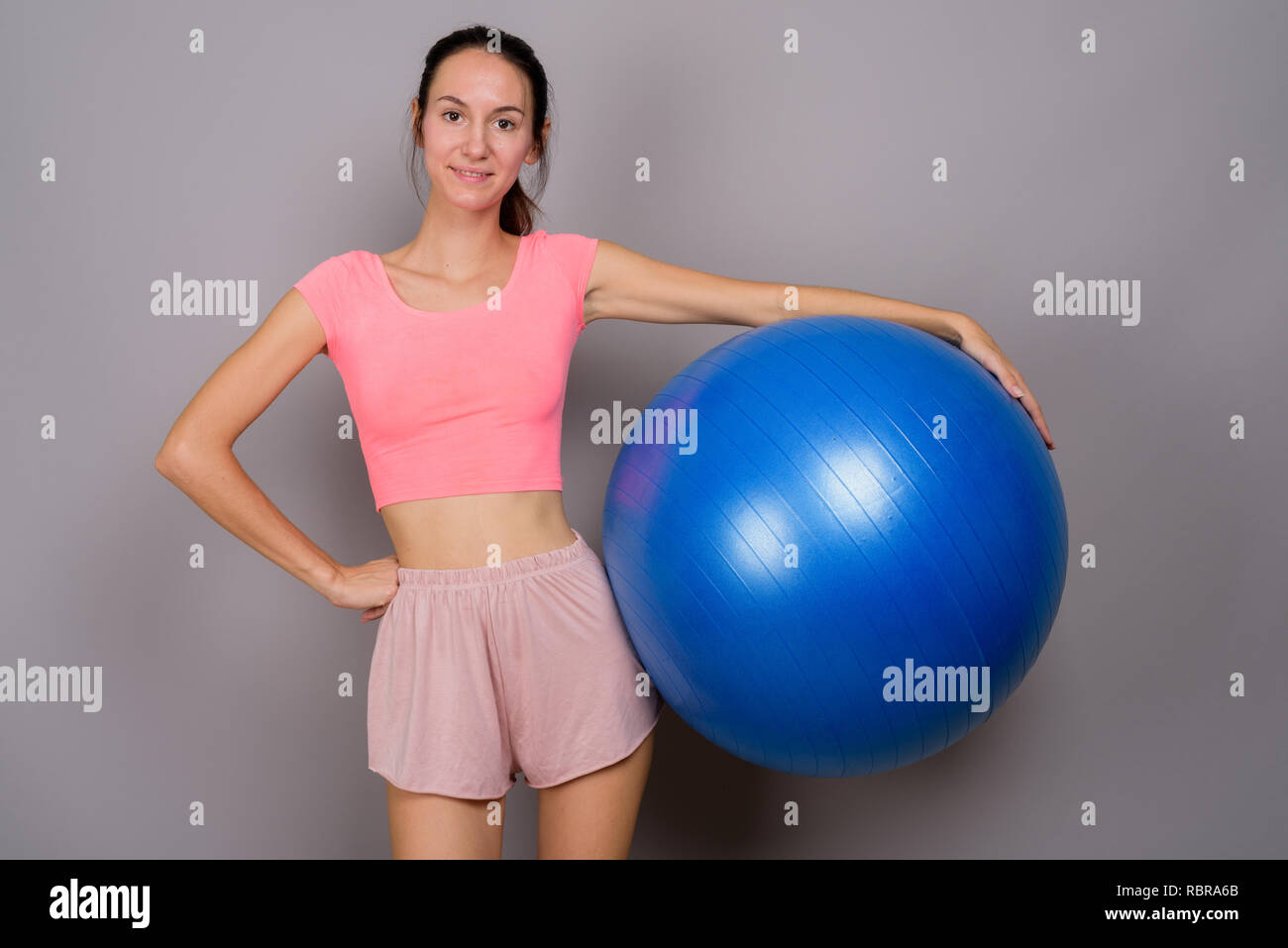 Belle jeune femme prête pour sport holding exercise ball Banque D'Images