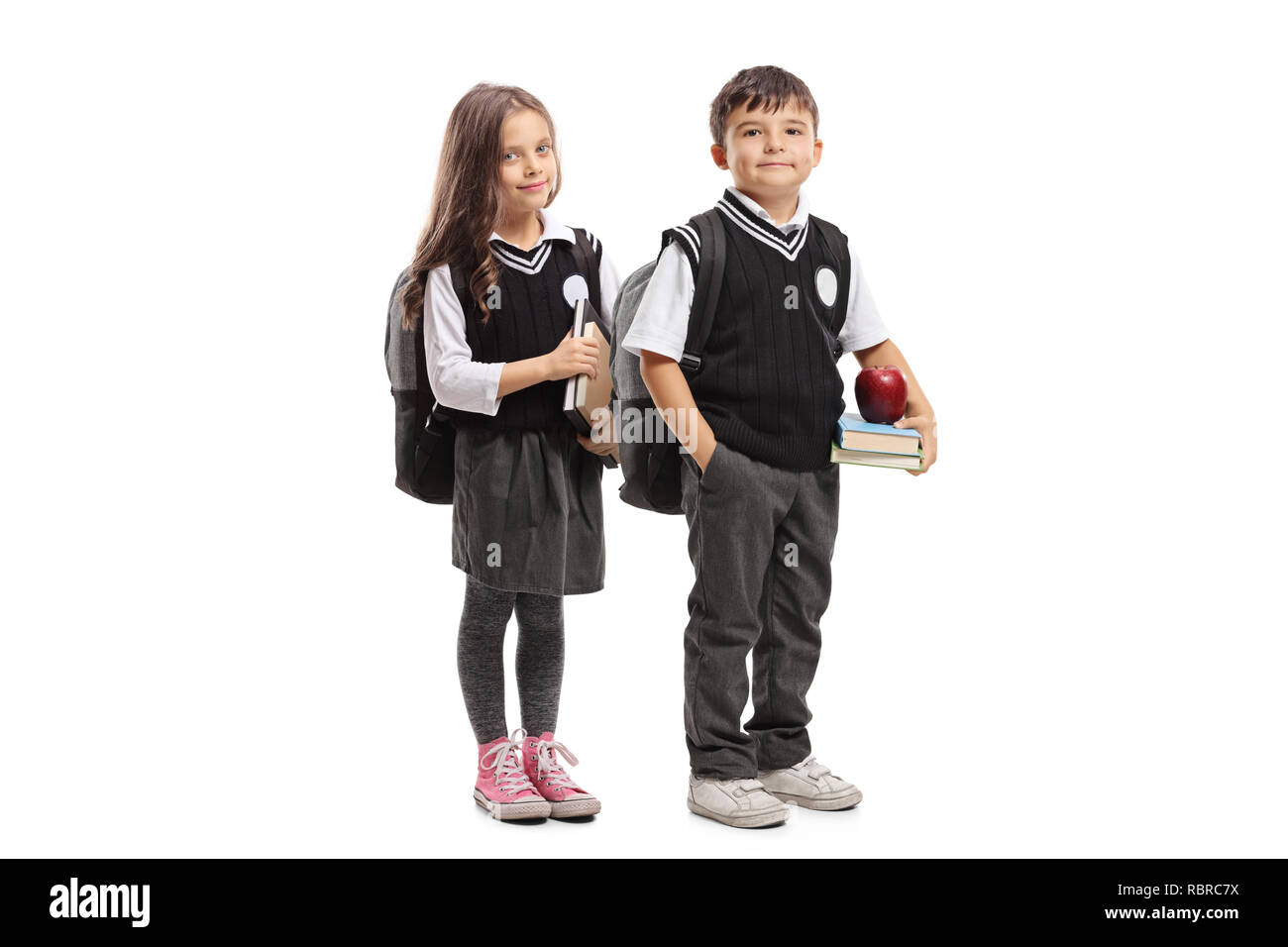Portrait d'une écolière et écolier en uniforme holding books et posant ...