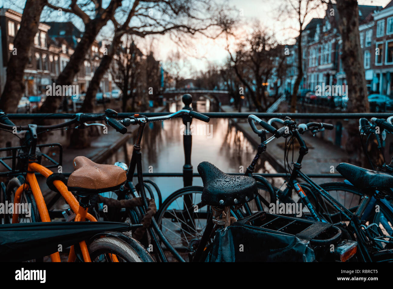 Des vélos sur un pont à Amsterdam, Pays-Bas par temps couvert humide transport destination vacances Banque D'Images