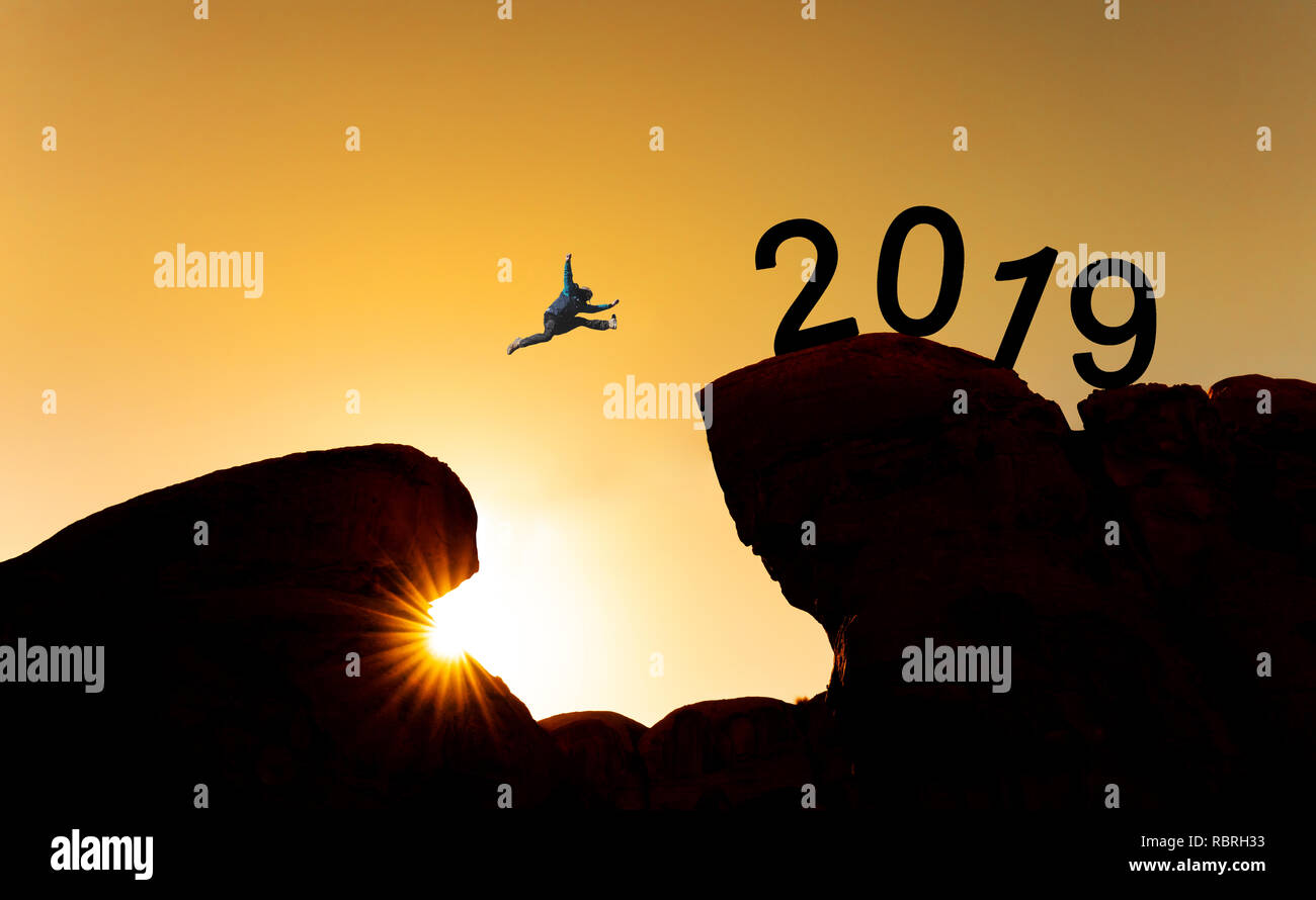 Nouveau concept de l'année, la silhouette d'un homme sautant sur falaise pour 2019 Banque D'Images