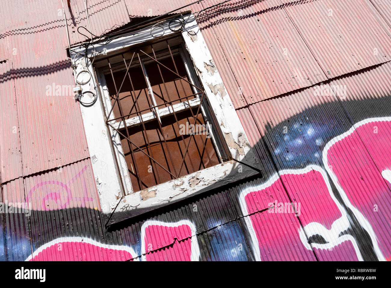 Une fenêtre d'un bâtiment revêtu de plaques de métal à Valparaiso, Chili. Banque D'Images