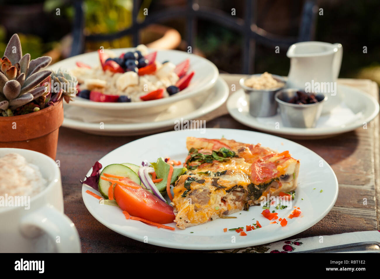 Quiche aux épinards et à la Pancetta avec salade et le gruau on outdoor table Banque D'Images