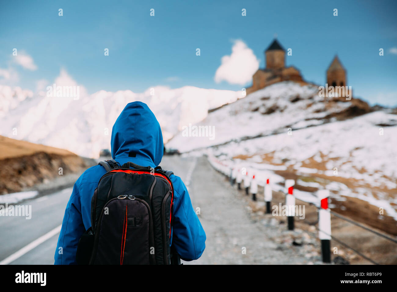 Stepantsminda Gergeti, Géorgie). Photographe Voyageur Backpacker touristiques homme marchant à l'église Holy Trinity - Tsminda Sameba. Belle Terre Géorgienne Banque D'Images