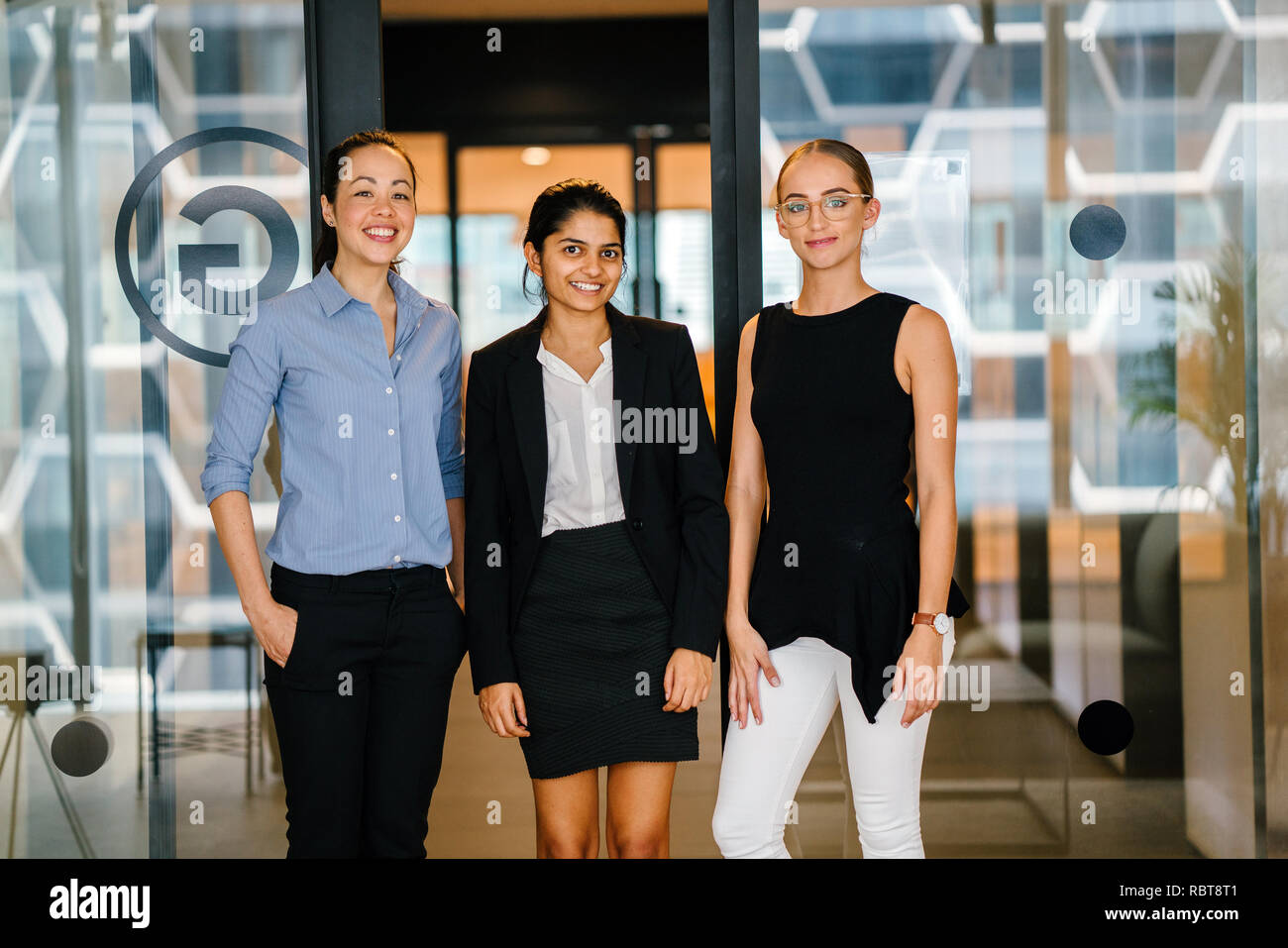 Portrait d'une équipe d'une grande diversité ethnique. C'est une femme de race blanche, l'autre indien et chinois de la dernière. Ils rient comme ils posent. Banque D'Images