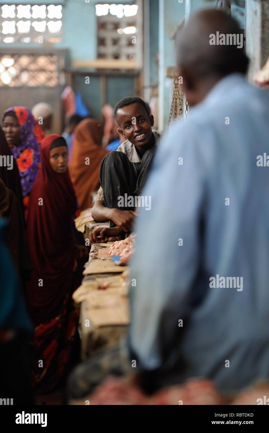 Un jeune homme parle avec son voisin à Hamar Weyne's Meat Market dans la capitale somalienne de Mogadiscio le 3 octobre. L'avant de l'Aïd al-Adha, bon nombre de résidents de Mogadiscio ont été occupés aujourd'hui préparer (15240819699). Banque D'Images