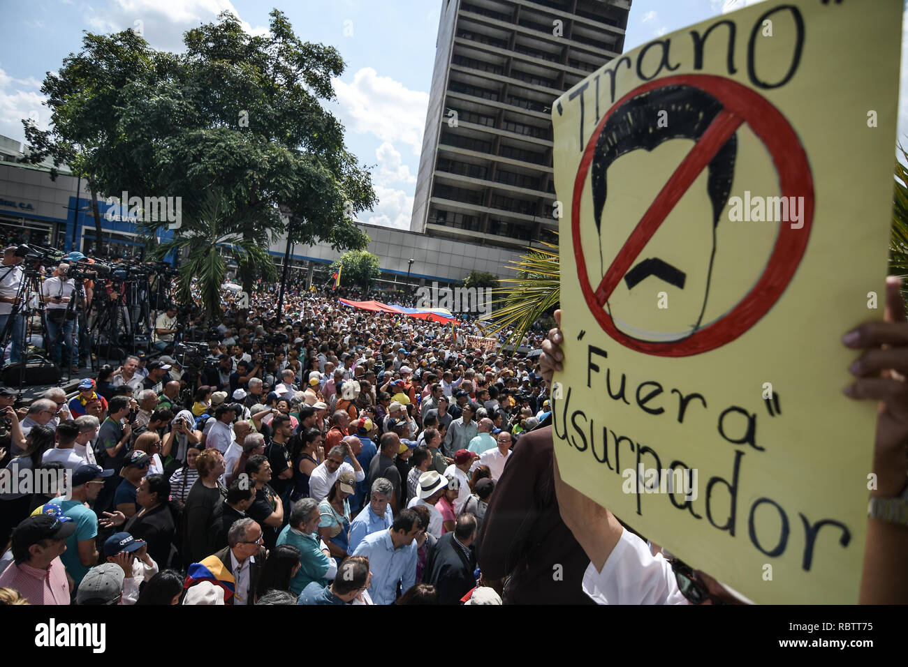 Caracas, Venezuela. Jan 11, 2019. Un homme est vu holding a placard avec le visage de Maduro barré qui lit 'tyran, les congés, l'usurpateur". Maduro a été élu pour un second mandat à la suite de l'élection de 2018, suivie par la critique internationale que son leadership du pays souffrant d'un effondrement est hyperinflationniste misbegotten. L'opposition, le 'Assemblée nationale' pour un gouvernement de transition. Credit : SOPA/Alamy Images Limited Live News Banque D'Images