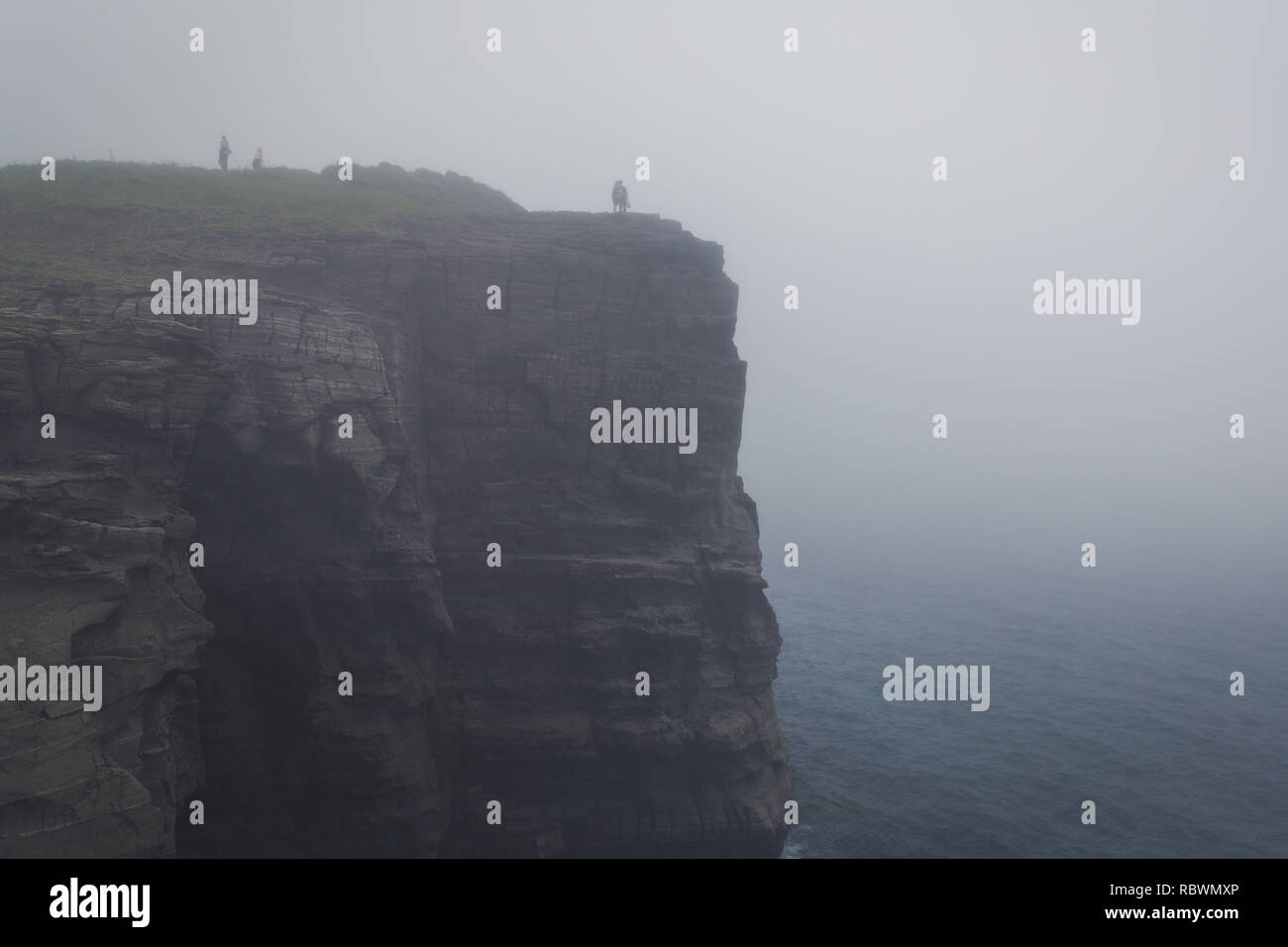 Haute falaise dans le brouillard et les gens sur le bord Banque D'Images
