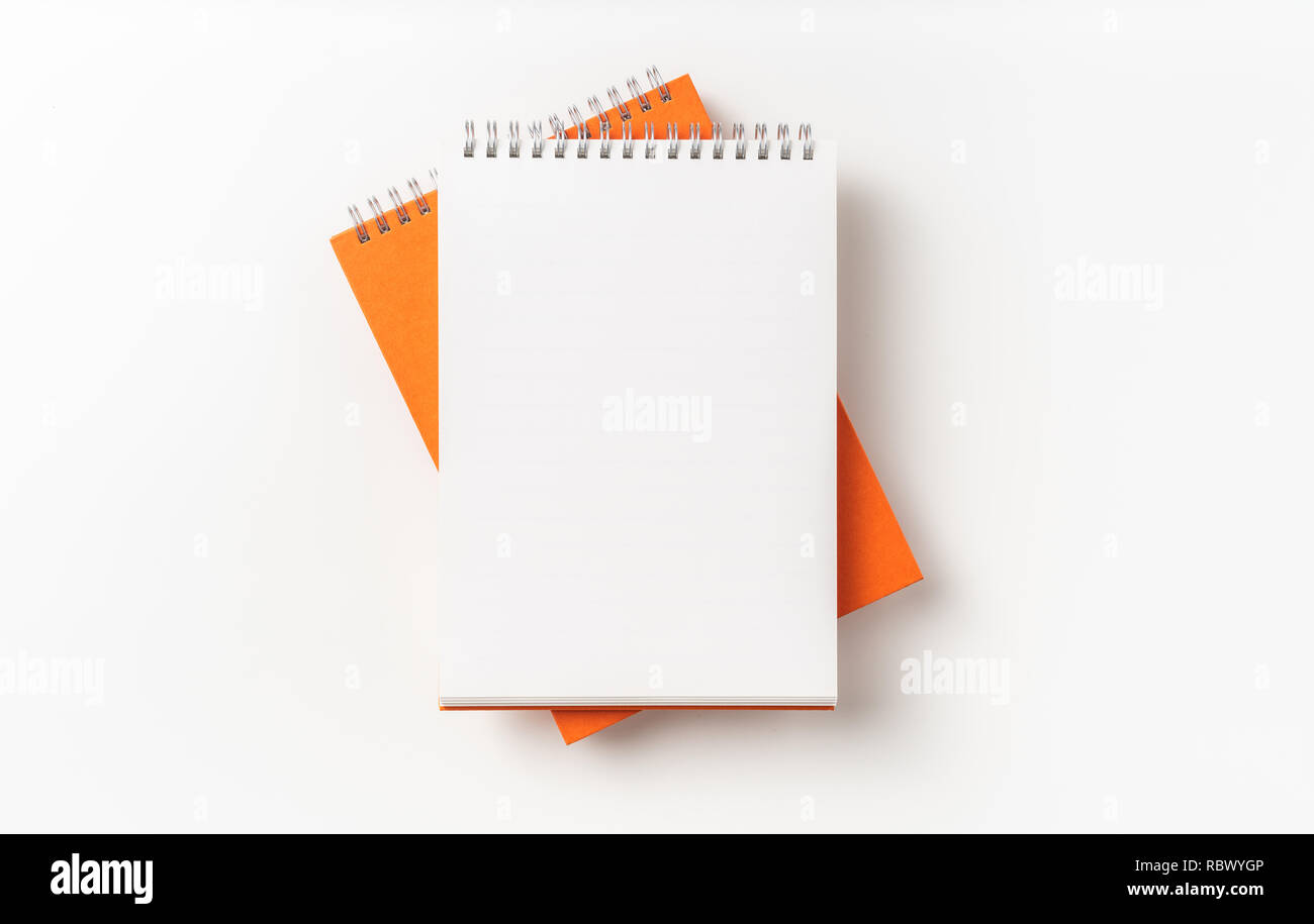 Concept design - Vue de dessus 2 carnet à spirales orange, blanc isolé sur fond de page immersive Banque D'Images