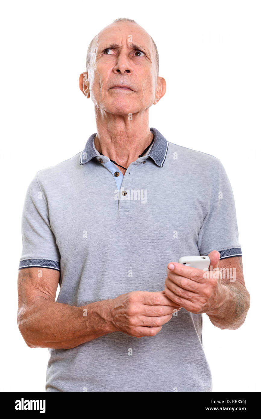 Portrait of senior man holding mobile phone en pensant Banque D'Images