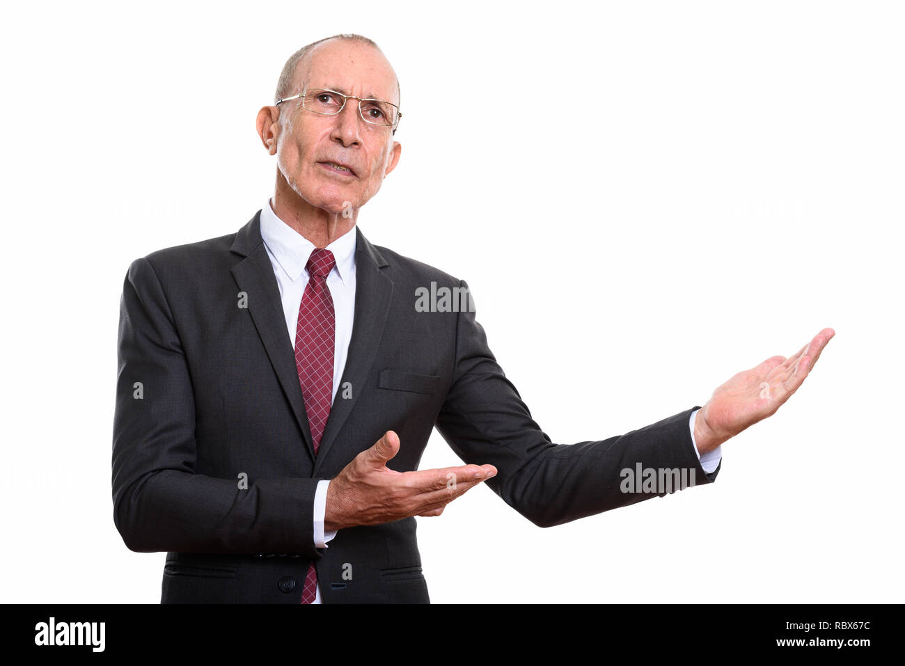 Studio shot of senior businessman montrant quelque chose Banque D'Images