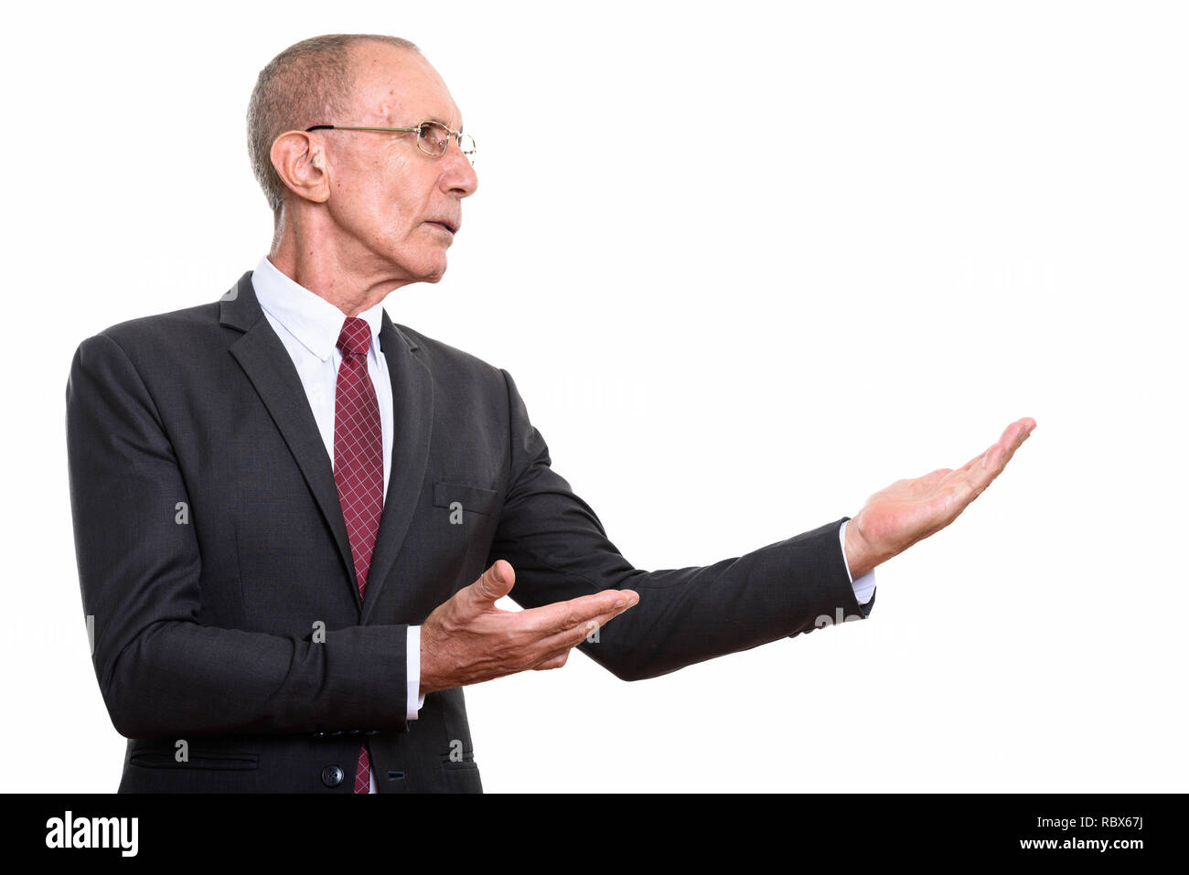 Vue de profil senior businessman montrant quelque chose Banque D'Images