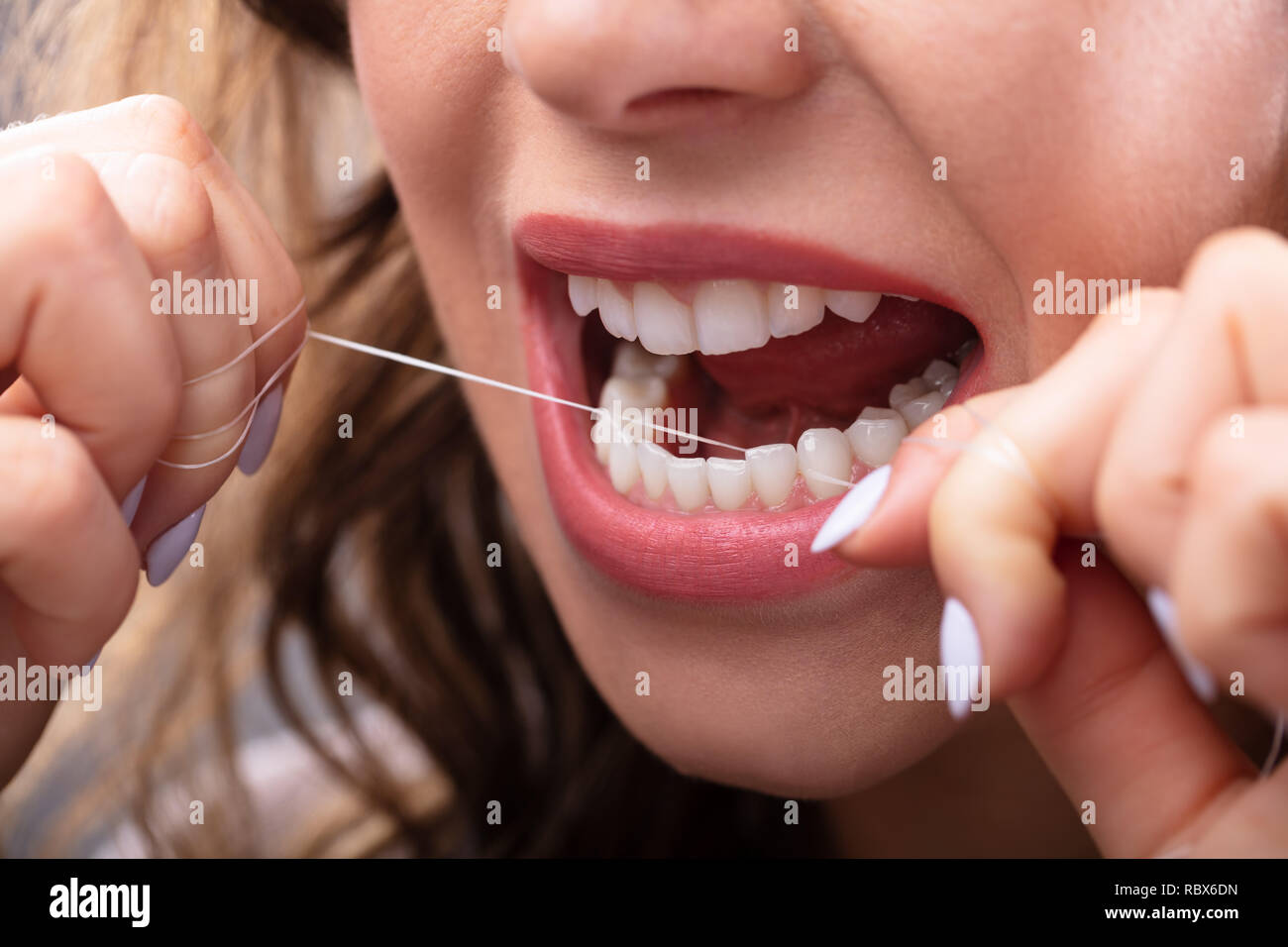 Close-up of a Woman's Hand Soie dentaire Les dents Banque D'Images