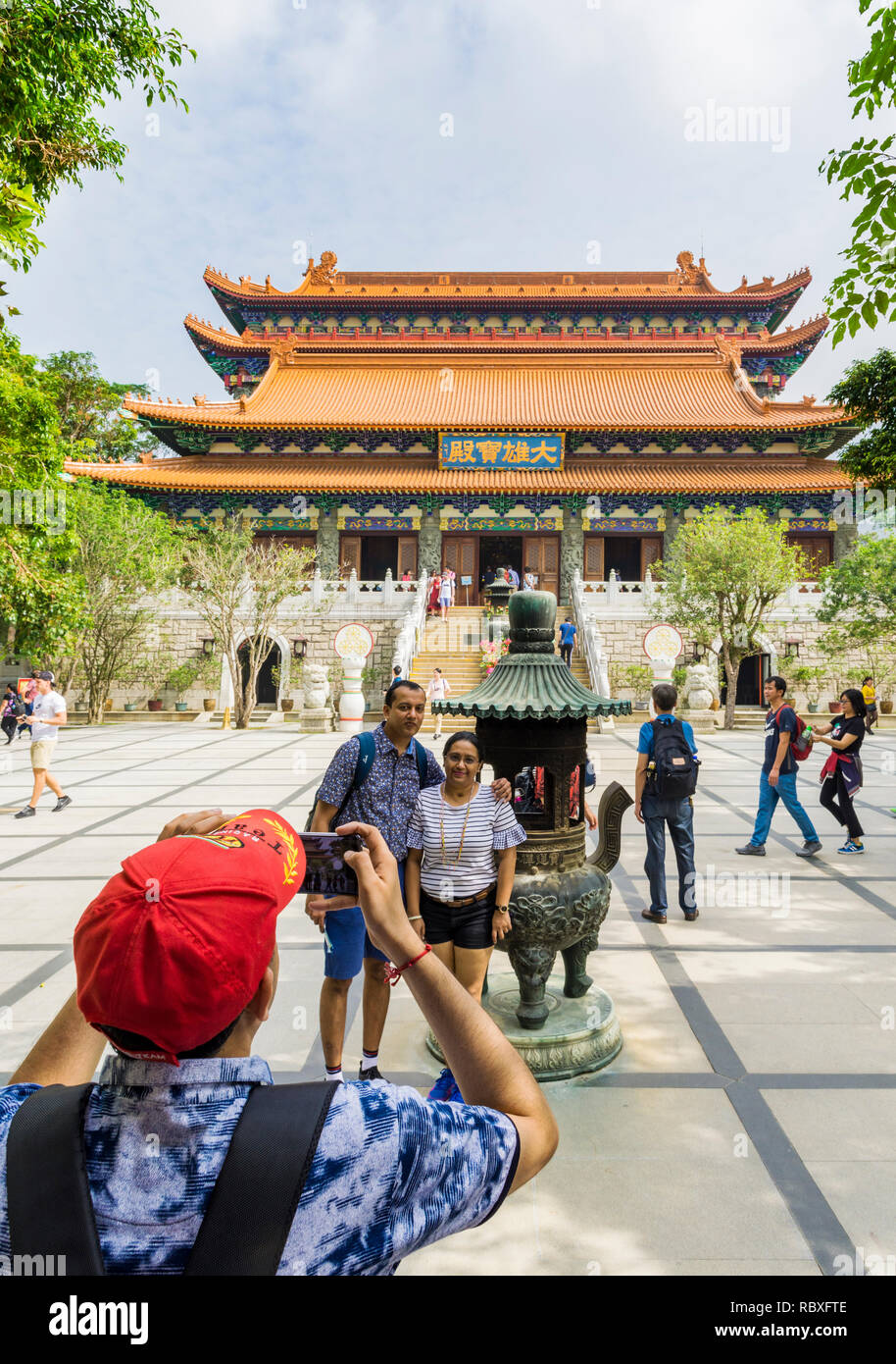 Un touriste prend une photo de personnes au monastère Po Lin, Lantau Island, Hong Kong Banque D'Images