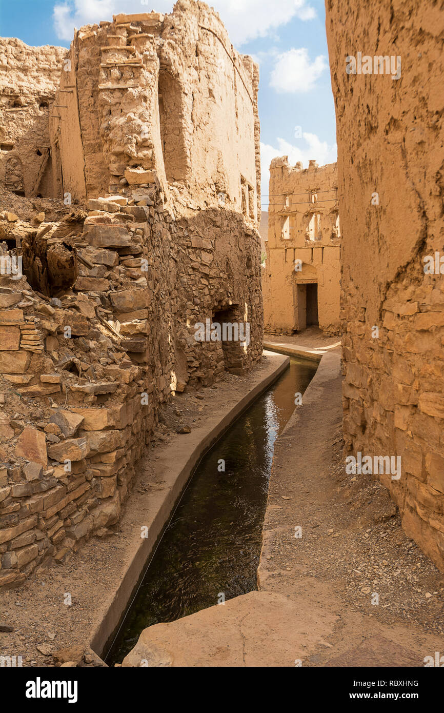 L'acheminement de l'eau (aflaj) dans les allées entre les maisons de boue semi-abandonnés de Birkat Al Mouz Banque D'Images