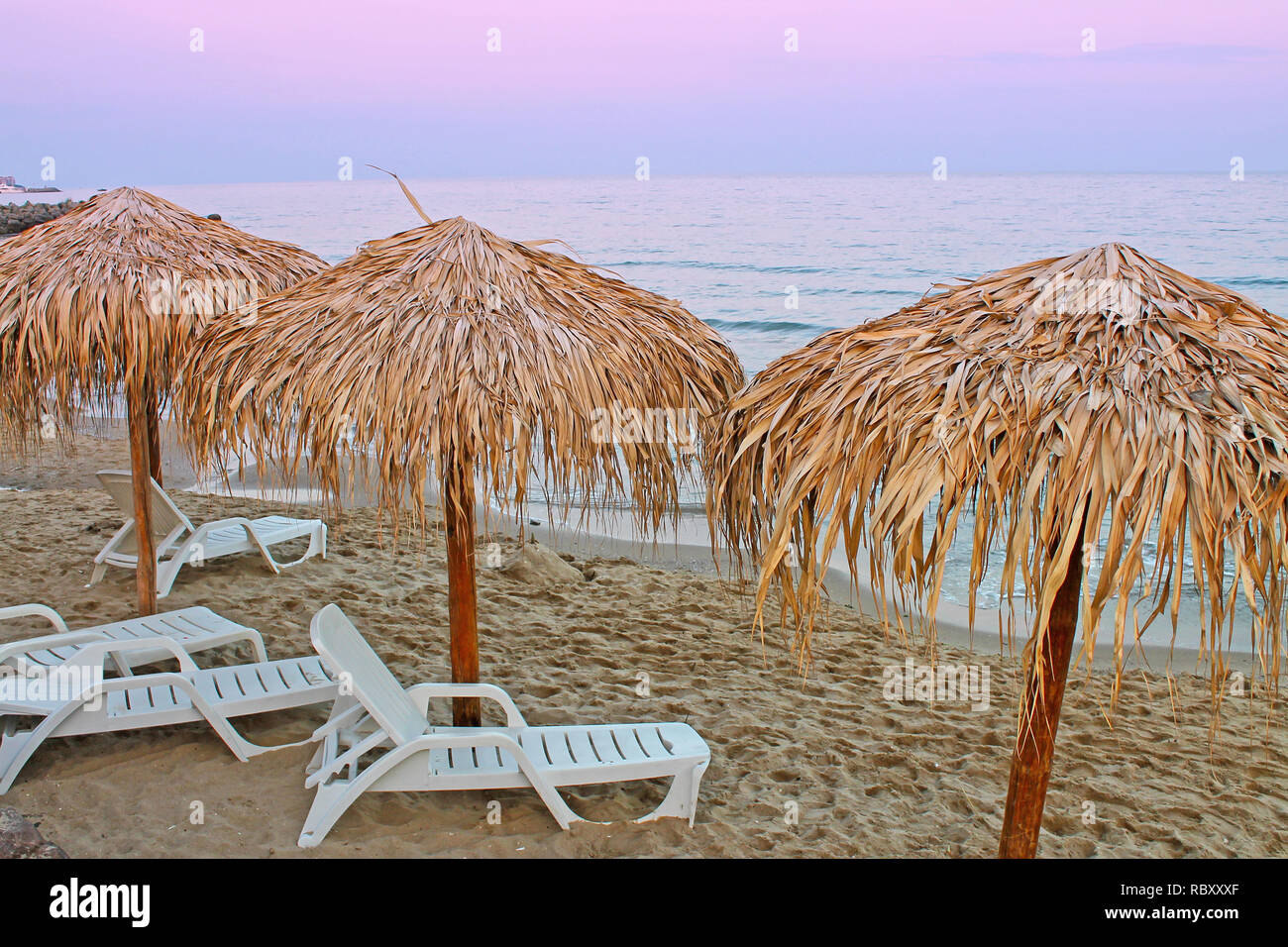 Vue sur la plage en Bulgarie avec des parasols de paille et de salons. Banque D'Images