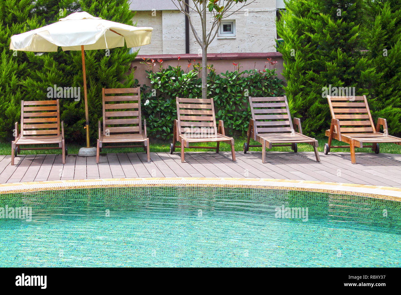 Piscine avec salons et parasol. Banque D'Images
