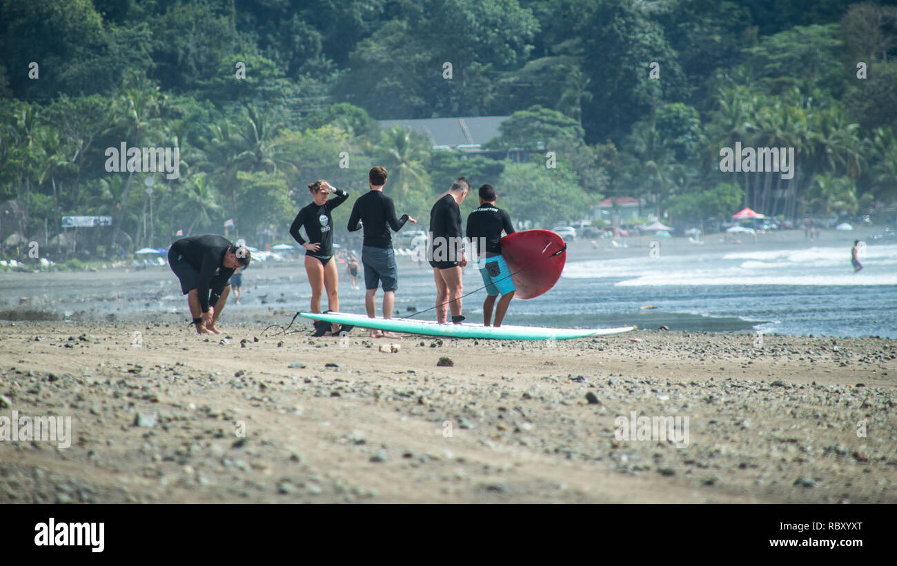 Un groupe de personnes qui se préparent pour une session de surf sur la magnifique plage de Jaco, Costa Rica Banque D'Images
