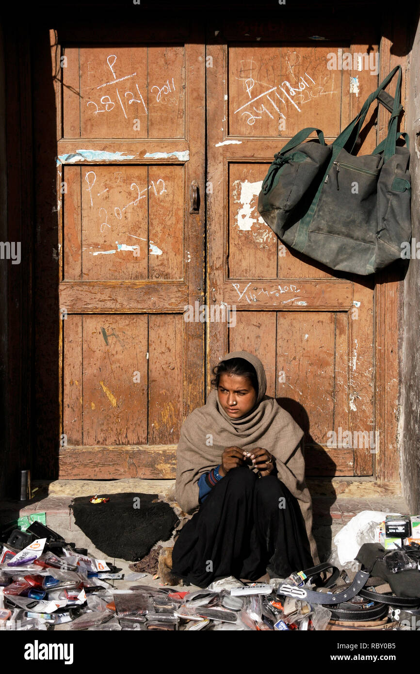 Leh, Ladakh, Inde - 3 octobre, 2018 : mauvaise fille indienne accessoires de vente mobile (cas, ceinture de cuir et de portefeuille) dans le marché local décroche à Ladakh Banque D'Images