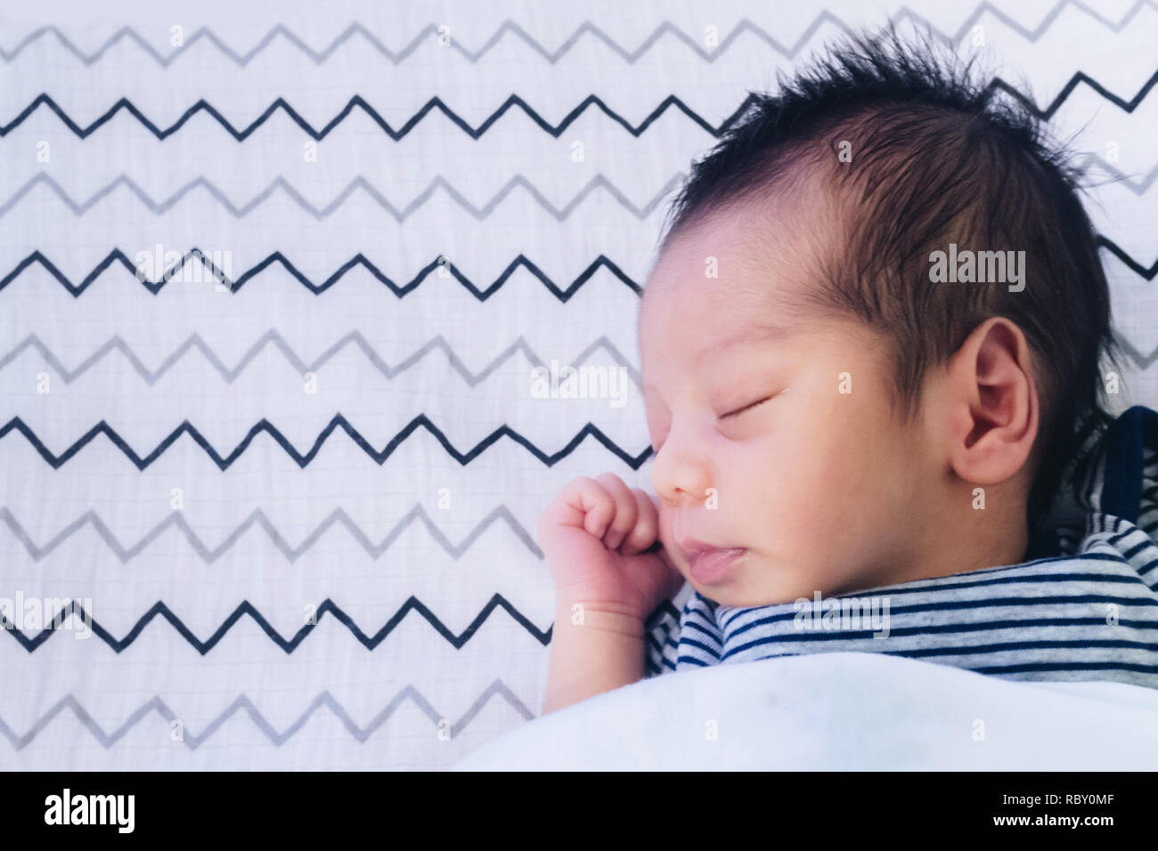 Close up de mignon petit bébé asiatique nouveau-né garçon endormi sur le lit chambre enfants avec copie espace. famille, de la vie, en bonne santé et de la relation concept. Banque D'Images