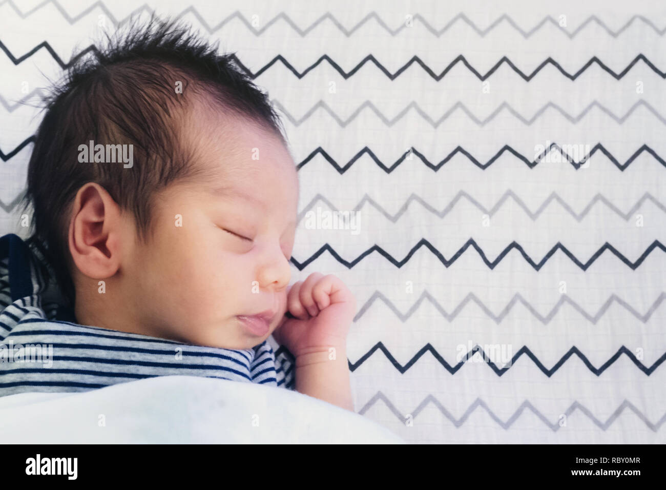 Close up de mignon petit bébé asiatique nouveau-né garçon endormi sur le lit chambre enfants avec copie espace. famille, de la vie, en bonne santé et de la relation concept. Banque D'Images