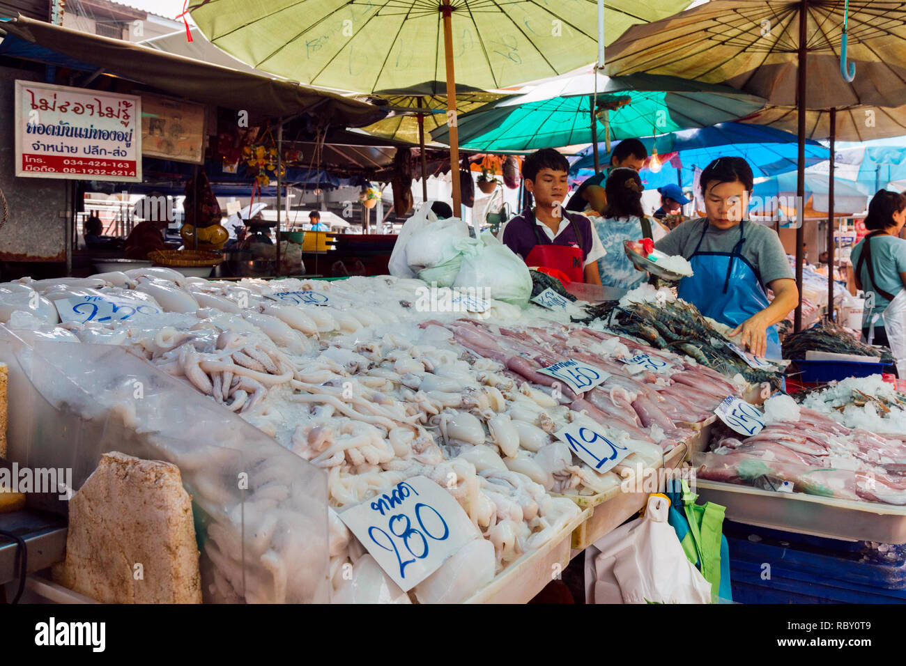 Samut Sakhon, Thaïlande - le 29 octobre 2018 asiatique : la préparation et verser le poissonnier sur glace river la crevette, le calmar et autres fruits de mer à vendre à stall Banque D'Images
