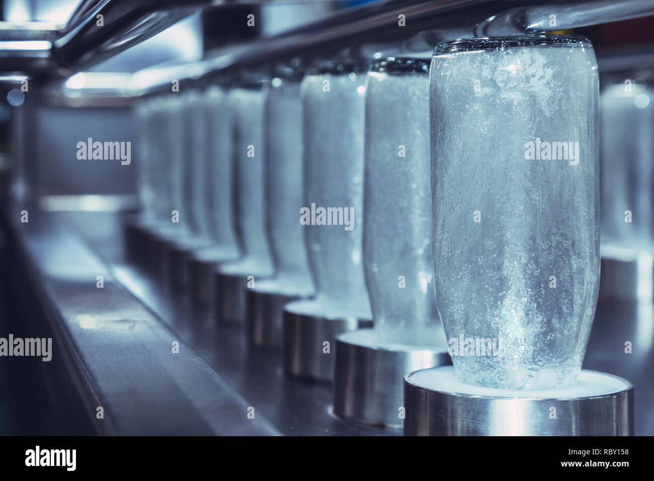 Bouteilles en verre clair pour la médecine, l'alimentation et boissons sont en processus de nettoyage d'hygiène par l'eau chaude dans la bouteille de verre automatique lave Banque D'Images