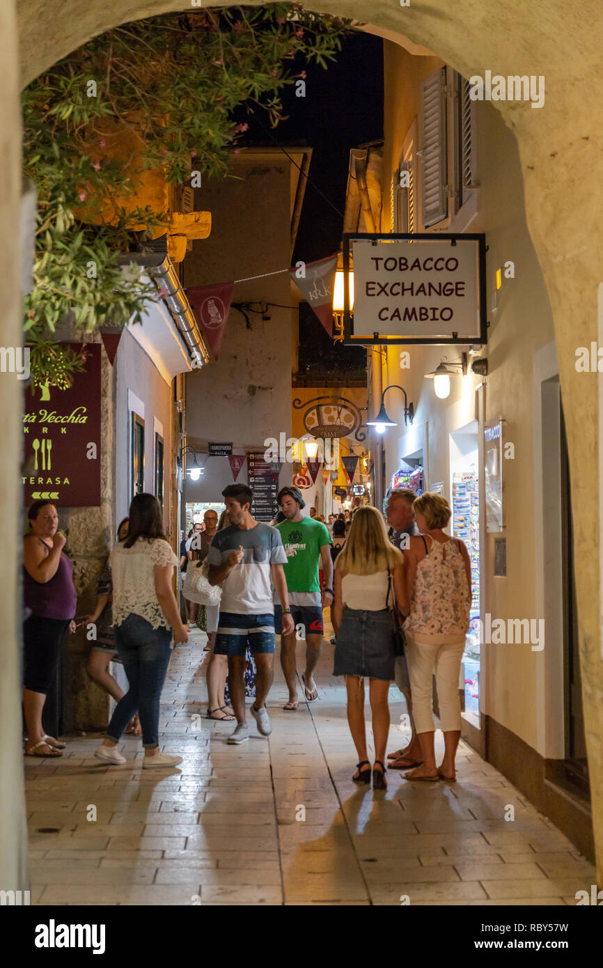 Les touristes serpentant à travers l'une des rues étroites de la vieille ville de Krk dans la soirée. Krk, Kvarner, Croatie Banque D'Images