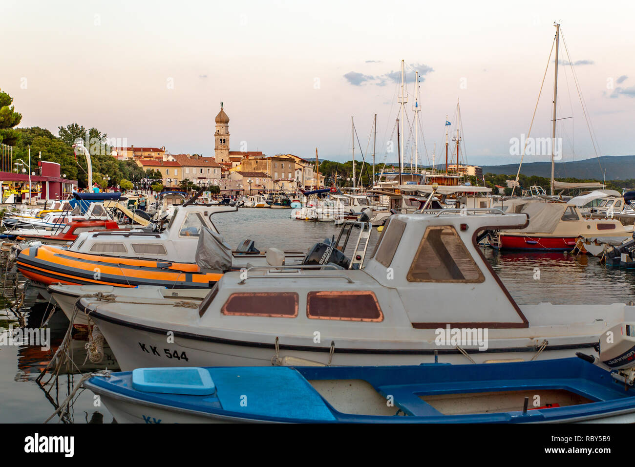 Tour de la cathédrale de l'Assomption de la Bienheureuse Vierge Marie avec des bateaux et des bateaux dans le port en face de la vieille ville historique de Krk. Banque D'Images