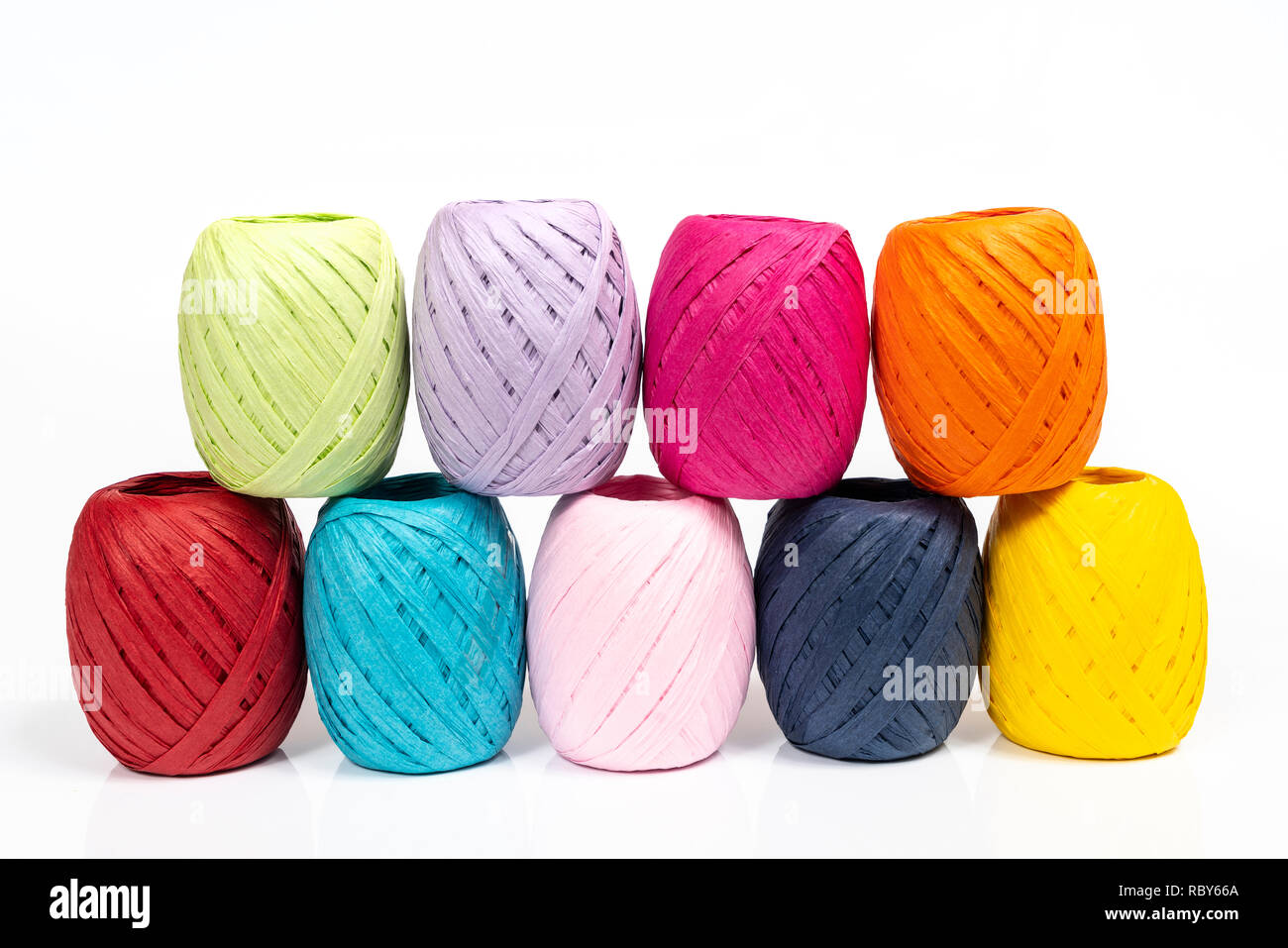 Quelques balles de raphia de couleur sur une surface blanche Banque D'Images