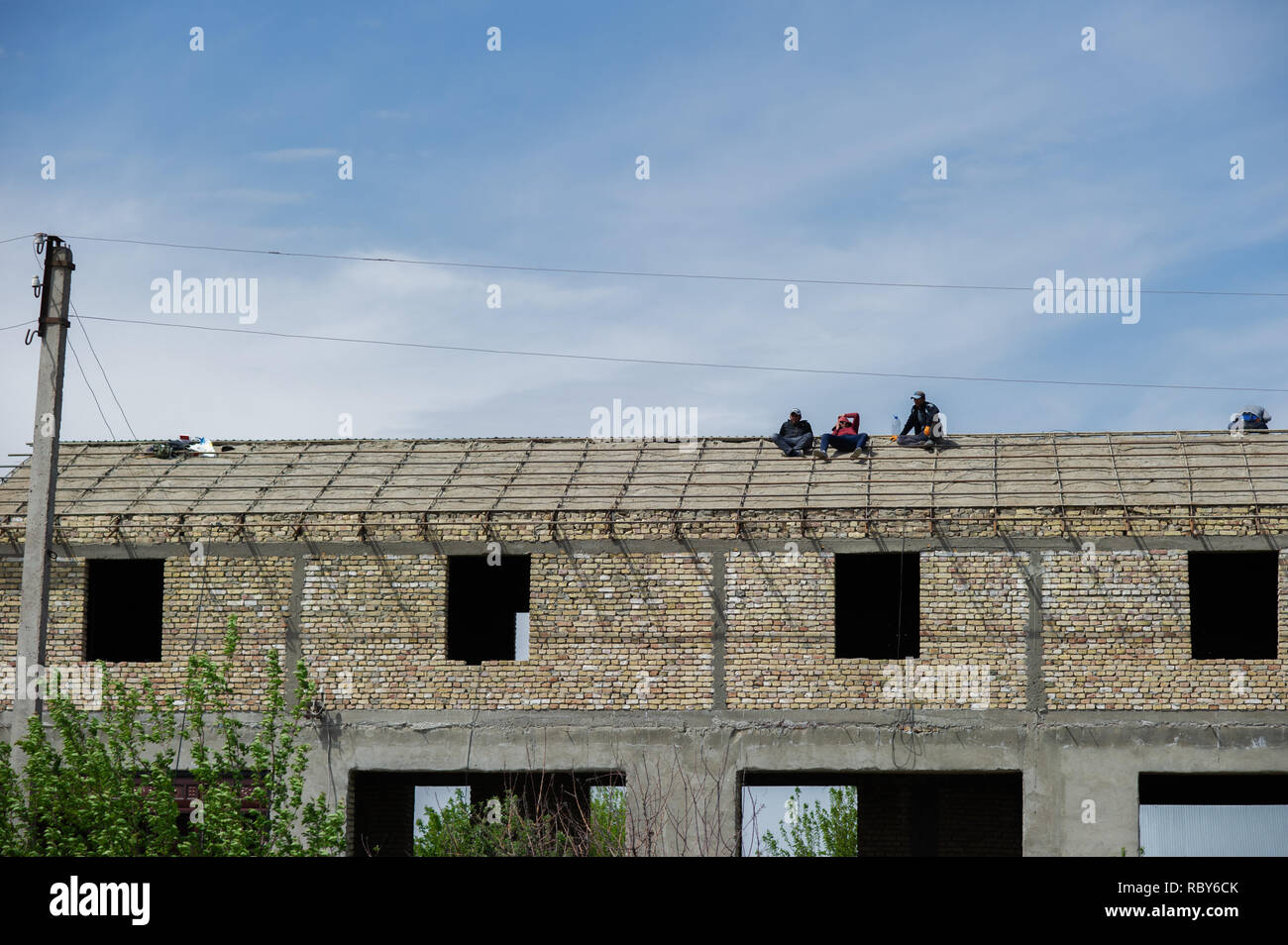 Les travailleurs de la construction reste sur le toit d'un bâtiment inachevé près de Boukhara, Ouzbékistan. Banque D'Images