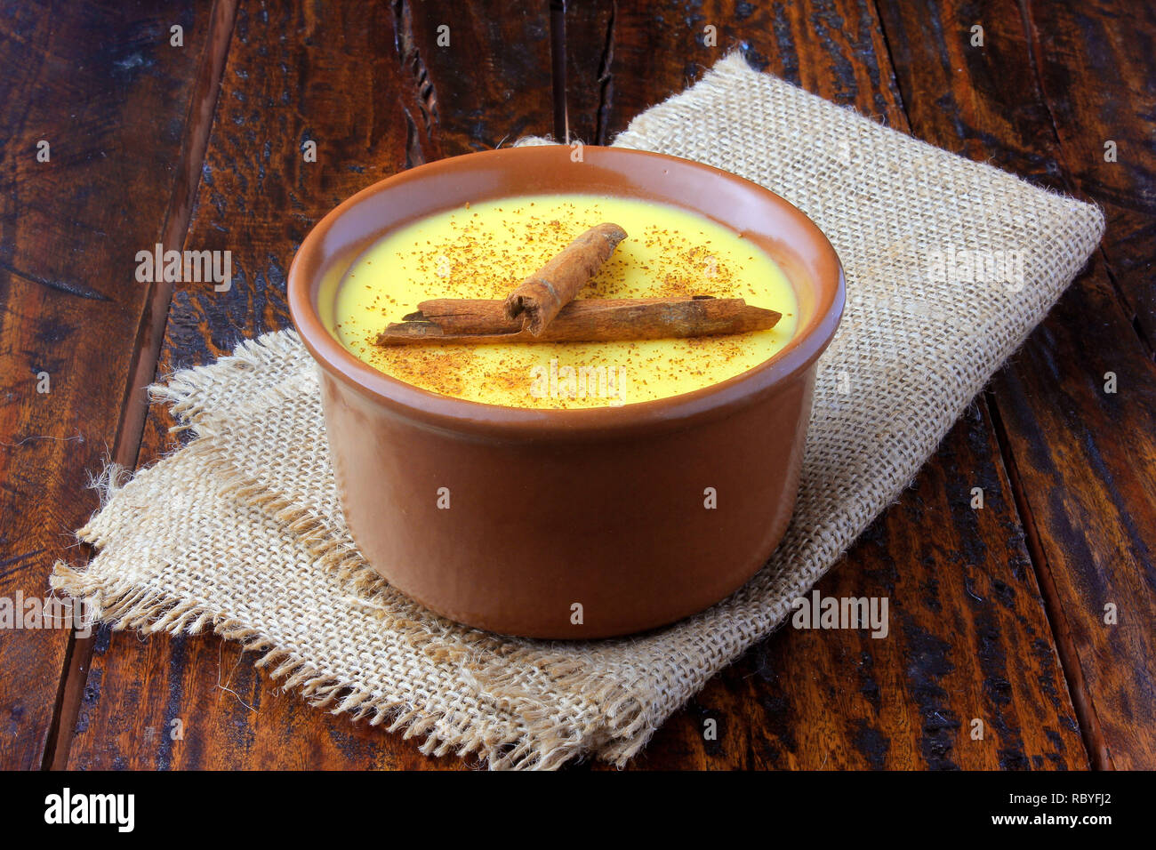 Curau, crème de maïs doux et un dessert typique de la cuisine brésilienne, avec de la cannelle placés dans le bol en céramique de table en bois. Copier l'espace. Close-up Banque D'Images