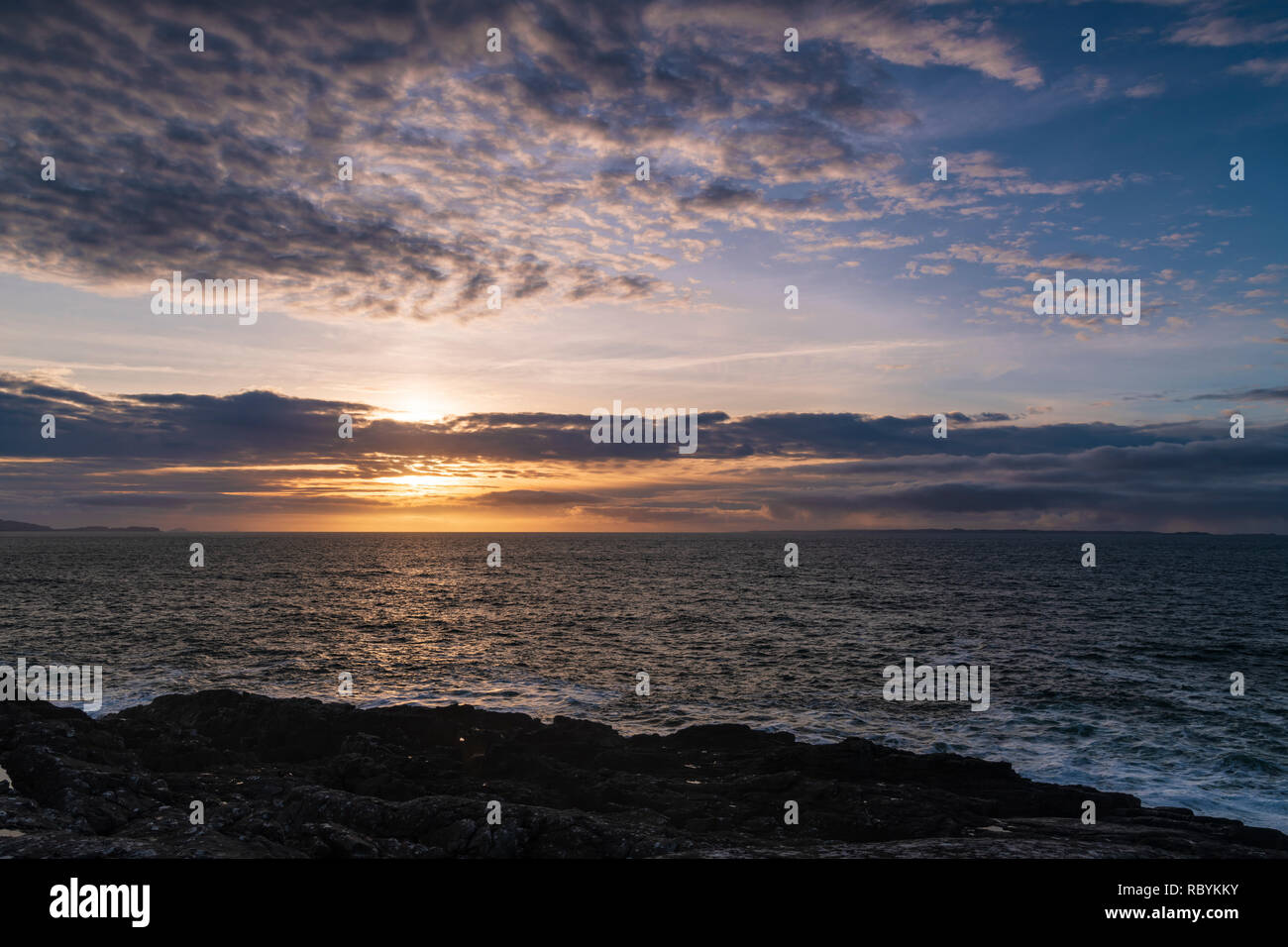 Le soleil se couche sur la mer des Hébrides avec l'île de Mull et coll dans la distance, à partir de 38, l'Ecosse. 29 Décembre 2018 Banque D'Images