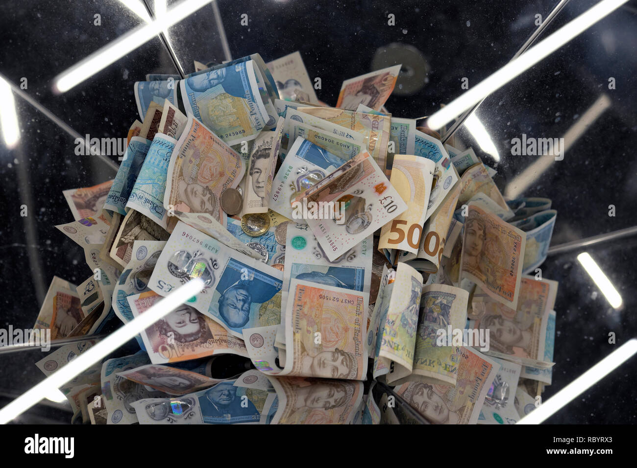 Une pile de papier et la sterling argent polymère £5 et £10 billets de banque dans une collection fort avec des reflets de lumière à Londres UK KATHY DEWITT Banque D'Images