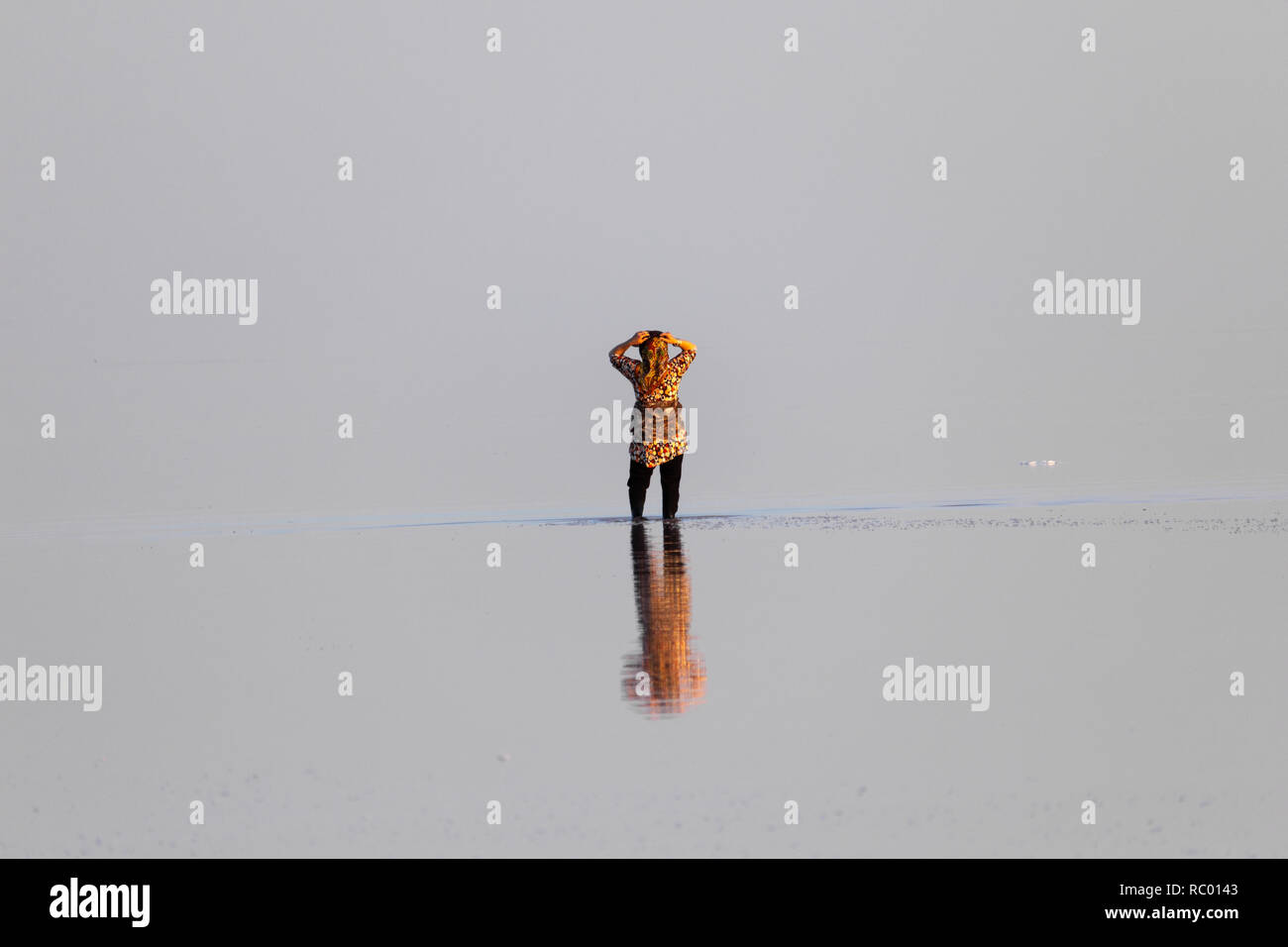 Une femme debout dans les eaux peu profondes du lac de sel d'Orumieh, province de l'Ouest, l'Iran Banque D'Images