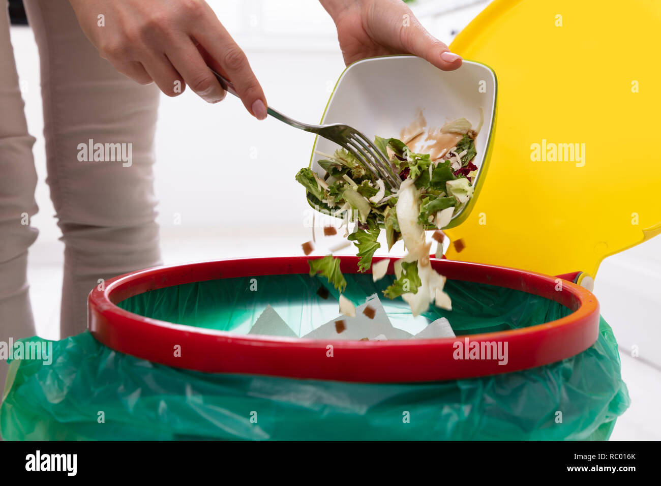 Close-up of a Woman's Hand Throwing Légumes dans Corbeille Banque D'Images