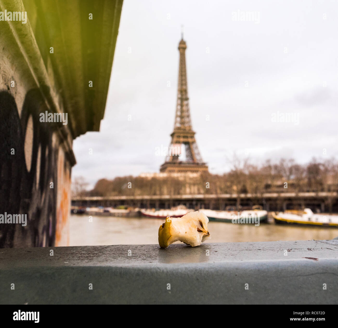 Mordu apple core à gauche sur le pont de Paris avec la Tour Eiffel en arrière-plan avec sun flare Banque D'Images