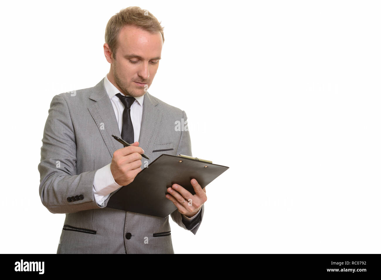 Beau Caucasian businessman writing on clipboard isolés contre fond blanc Banque D'Images