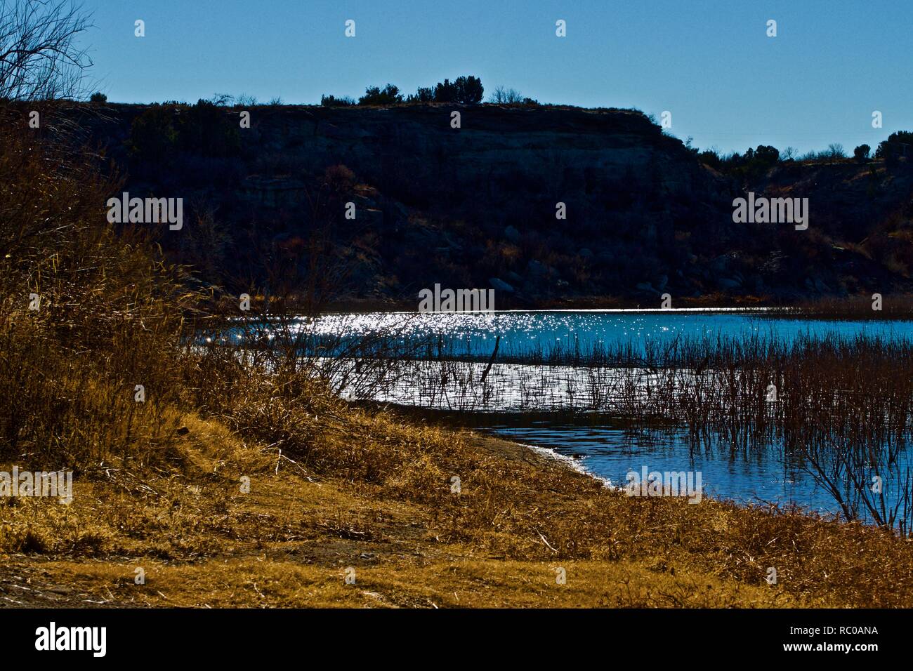 La lumière du soleil de l'après-midi Réflexions sur l'eau et des vasières au lac de McKinsey, Texas, près d'Amarillo. Banque D'Images