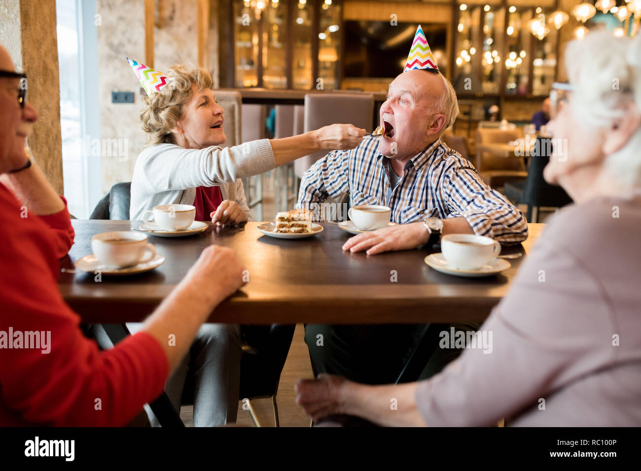 L'homme grassouillet gâteau dégustation du spoon, donnée par sa femme Banque D'Images