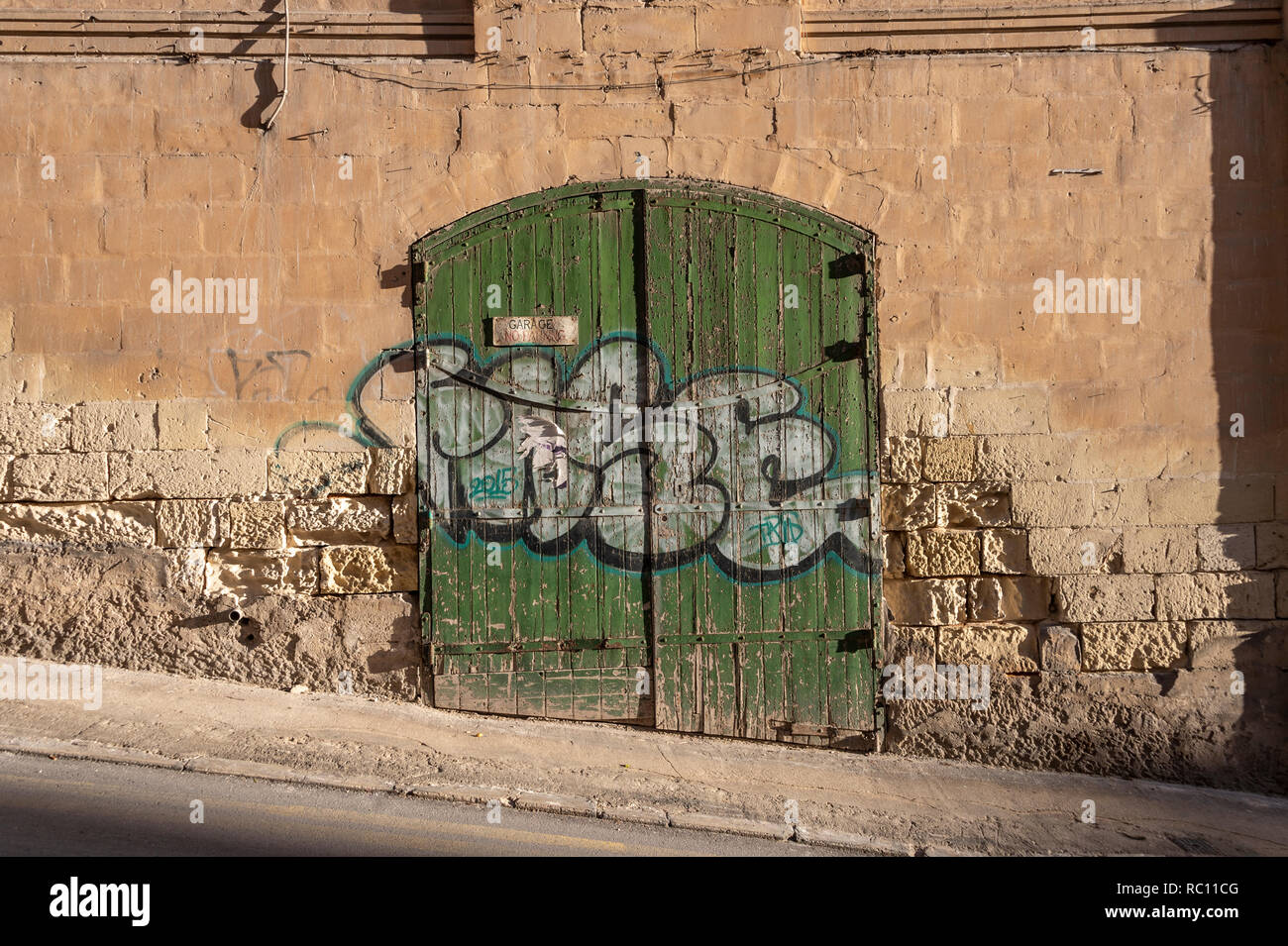 Old weathered green porte de garage dans une rue de Silema, Malte. Banque D'Images