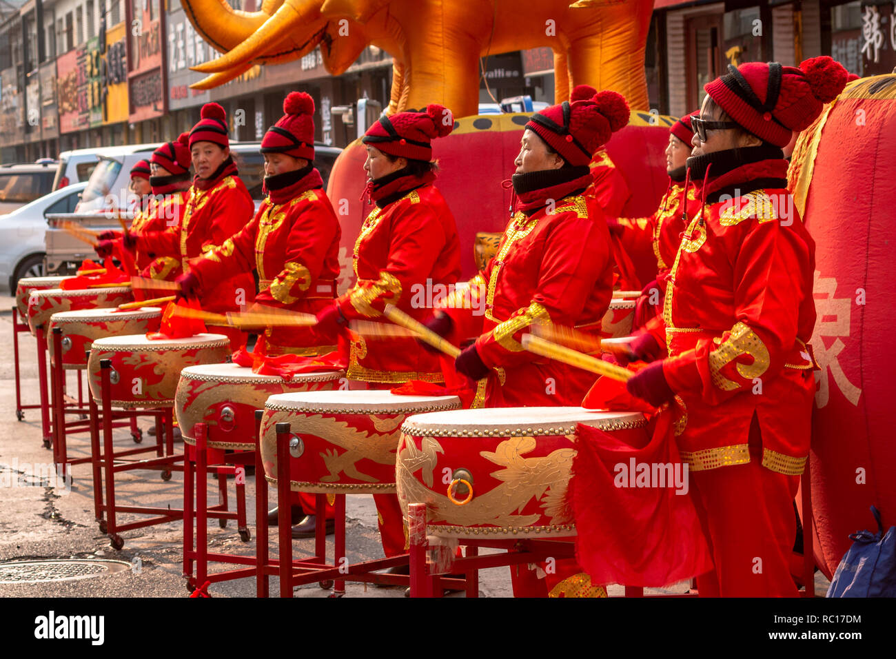 Les femmes dans des tenues d'or rouge tambour pendant le cérémonial de l'ouverture d'un magasin à Shanghai ville de Chine, la province de Jilin dans la préfecture de Yanbian Banque D'Images